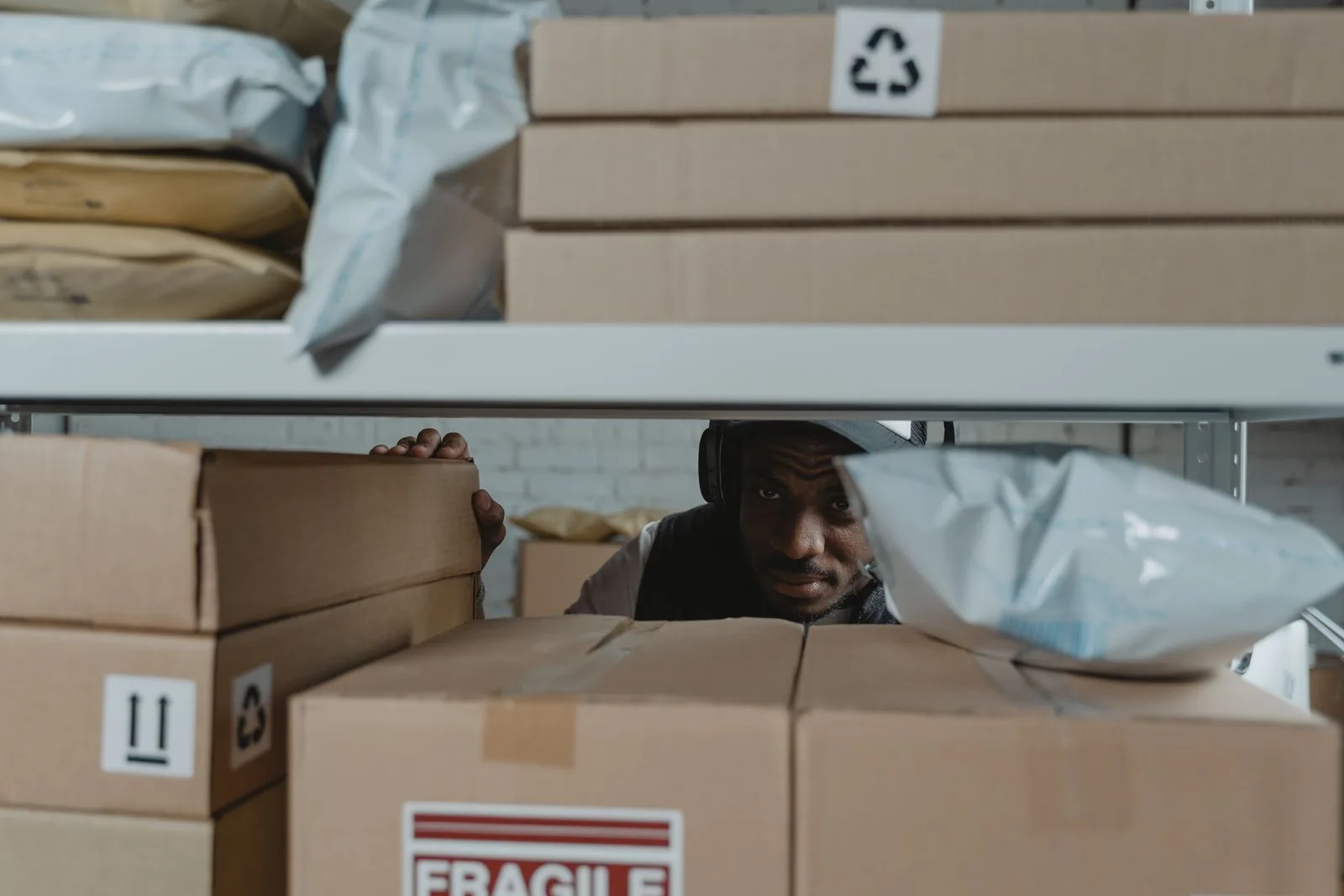 Warehouse worker inspecting labelled parcel shelves for consolidated SME import delivery